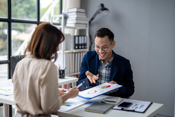 A man and a woman are sitting at a desk with a presentation in front of them