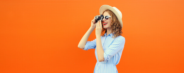 Portrait of happy young woman photographer with film camera, modern girl taking a picture in summer