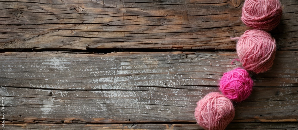 Poster pink balls of wool resting on an aged wooden surface with ample copy space image available