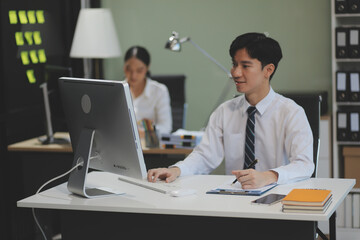 Modern Office Businessman Working on Computer. Portrait of Successful Latin IT Software Engineer Working on a Laptop at his Desk. Diverse Workplace with Professionals. Front View Shot