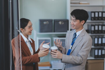 Successful young business people talking, working together in front of modern business building
