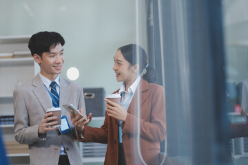 Successful young business people talking, working together in front of modern business building