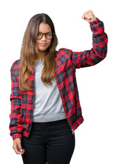 Young beautiful brunette woman wearing jacket and glasses over isolated background Strong person showing arm muscle, confident and proud of power