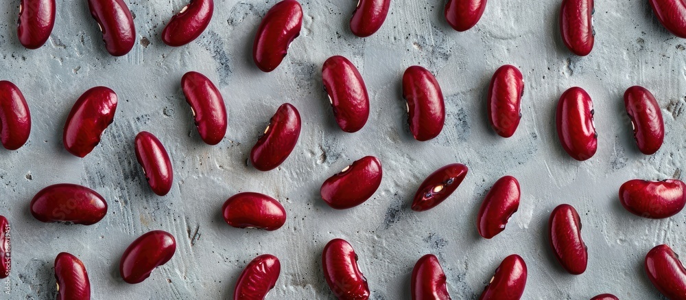 Poster horizontal top view of a pattern featuring red beans on a grey backdrop with ample copy space image