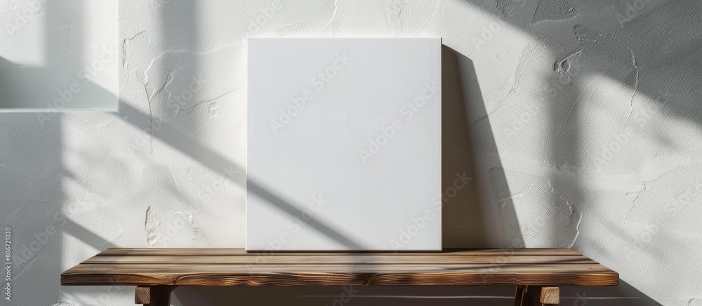 Aufkleber horizontal blank canvas on a wooden table against a white wall with shadows suitable for adding cont