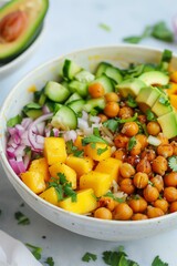 vibrant mango chickpea rice bowl, featuring fresh diced mango, roasted chickpeas, avocado, cucumber, red onion, and cilantro, creating a colorful and healthy vegan meal