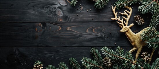 Copy space image featuring a Christmas themed frame spruce branches a golden deer set against a black wooden backdrop