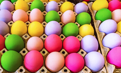 Multicolored easter eggs in egg tray. Creative Easter concept. Colorful handmade Easter eggs in paper container. Multicolored eggs in a cardboard egg carton. Egg in recycled basket protein breakfast.