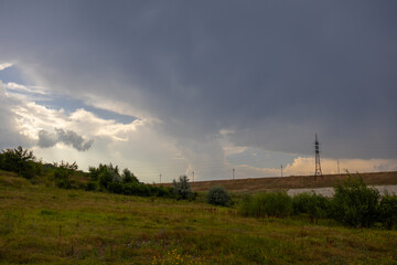 Cloudy sky above the green plain is preparing for a rain