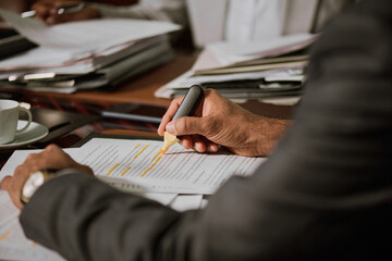 Focus on hand of experienced male lawyer or director of company underlining some lines of contract...