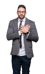 Young handsome business man over isolated background smiling with hands on chest with closed eyes and grateful gesture on face. Health concept.