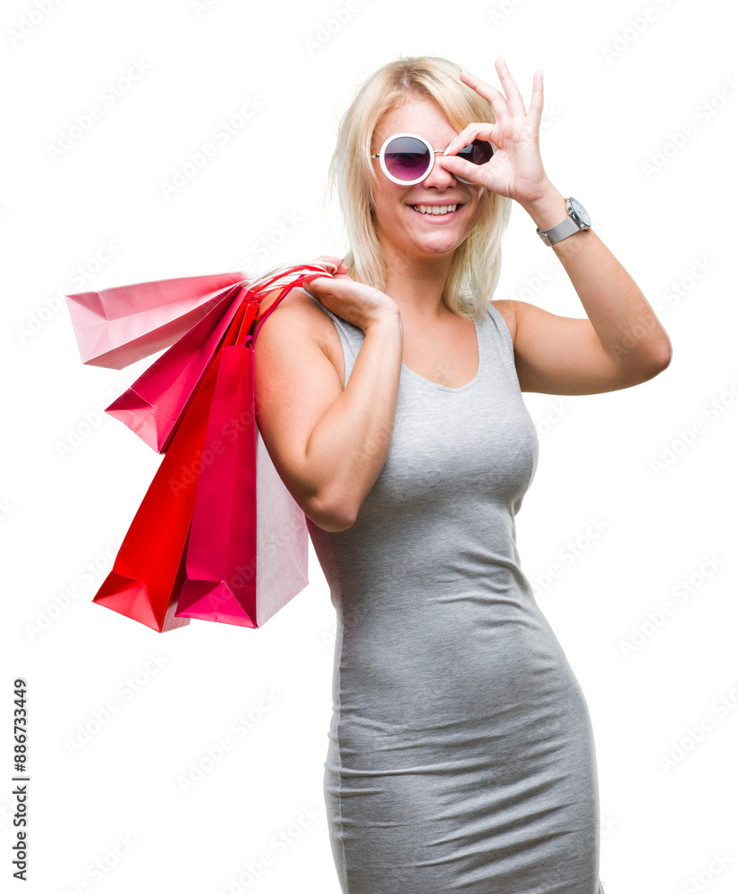 Sticker young beautiful blonde woman shopping holding shopping bags on sales over isolated background with h