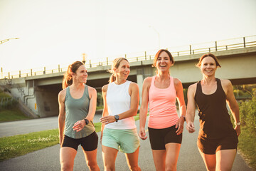 females in sportswear walking together bright sunny park in summer