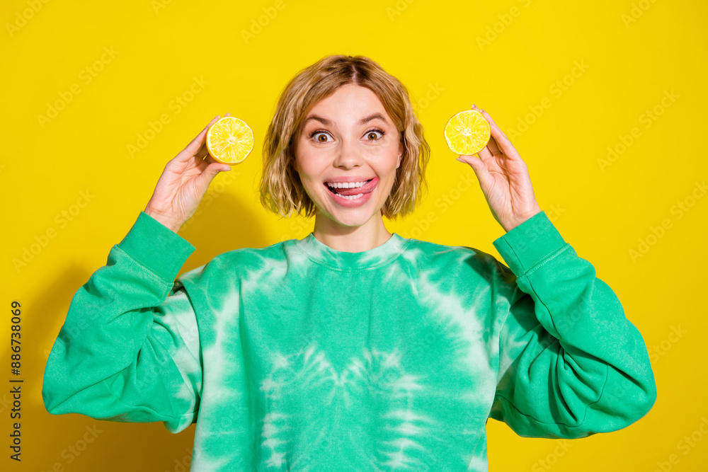 Wall mural Photo of shiny attractive lady dressed tie dye sweatshirt stick out showing two lemon slices empty space isolated yellow color background