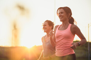 Two athletic women in sportswear is jogging together