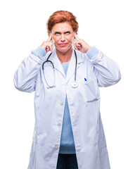 Senior caucasian doctor woman wearing medical uniform over isolated background covering ears with fingers with annoyed expression for the noise of loud music. Deaf concept.