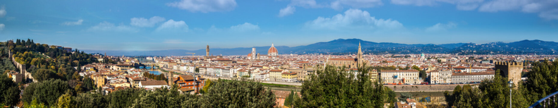 Panoramic view of cityscape with cathedral Santa Maria del Fiore and Ponte Vecchio with mountain backdrop, Florence, Tuscany, Italy