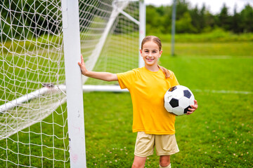 Kid play football on outdoor field at the end of the day