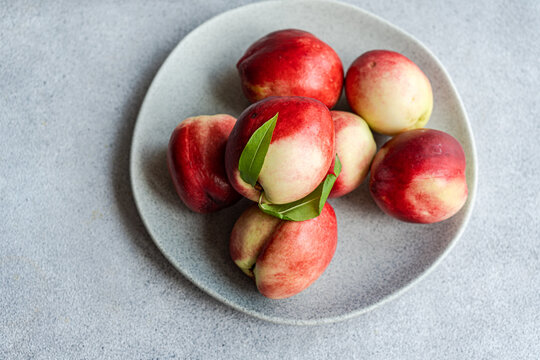 Overhead view of a plate of ripe nectarines on a  table