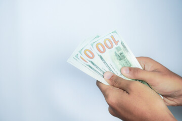 finance, currency and people concept - close up of hand holding 100 dollar banknotes over white background