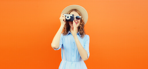 Portrait of happy young woman photographer with film camera, modern girl taking a picture in summer