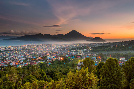 Aerial coastal cityscape at sunset, Ternate island, North Maluku, Maluku Islands, Indonesia