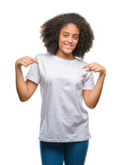 Young afro american woman over isolated background looking confident with smile on face, pointing oneself with fingers proud and happy.