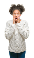 Young afro american woman wearing winter sweater over isolated background afraid and shocked with surprise expression, fear and excited face.