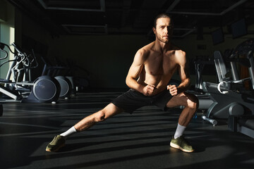 Fototapeta premium A shirtless muscular man working out in the gym, showcasing his toned physique and strength.