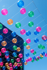 People walk along the shopping street called Meritxell decorated with colorful balls in the capital Andorra la Vella, Andorra in 2024.