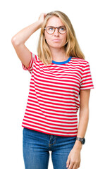 Fototapeta premium Beautiful young woman wearing glasses over isolated background confuse and wonder about question. Uncertain with doubt, thinking with hand on head. Pensive concept.