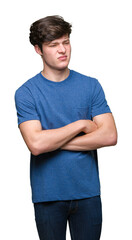 Young handsome man wearing blue t-shirt over isolated background skeptic and nervous, disapproving...