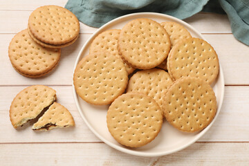 Fresh tasty sandwich cookies on wooden table, top view
