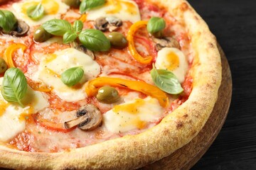 Delicious vegetarian pizza on black wooden table, closeup