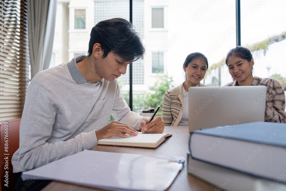 Poster group of student studying together in a modern library with laptops and notebooks