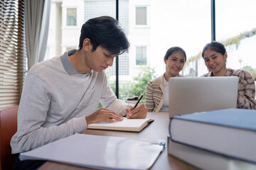 Group of Student Studying Together in a Modern Library with Laptops and Notebooks
