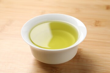 Refreshing green tea in cup on wooden table, closeup