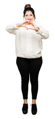 Young beautiful woman wearing winter sweater smiling in love showing heart symbol and shape with hands. Romantic concept.