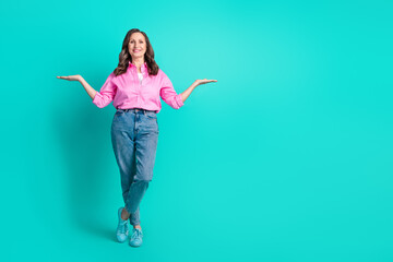 Full length photo of adorable lovely woman wear pink shirt showing arms scales empty space isolated blue color background