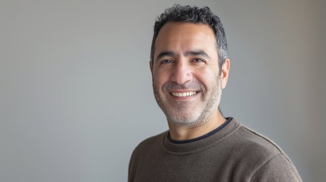 Friendly Middle Aged Man Smiling, Middle Eastern, Casual Attire, Gray Background, Portrait for Professional and Personal Use