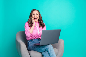 Photo of adorable excited woman wear pink shirt sitting armchair typing modern device empty space isolated blue color background