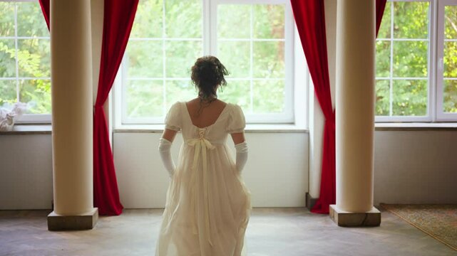 young woman is running in room looking out the window, waiting for love beloved man. Fantasy fairy lady Happy Princess girl, white silk vintage long dress old style ivory color back rear view. art 4k