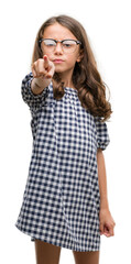 Brunette hispanic girl wearing glasses pointing with finger to the camera and to you, hand sign, positive and confident gesture from the front