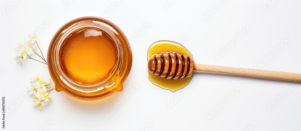Poster top-view image of a honey jar with a wooden dipper on a white background, displaying a delicious bot