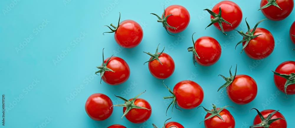 Poster Cherry tomatoes arranged with a background color of blue providing copy space image.