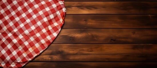 Obraz premium Wooden table backdrop with checkered napkin, suitable for promoting pizza and food items with copy space image.