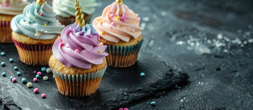 Poster Unicorn cupcakes creatively displayed on a black slate with ample copy space image.