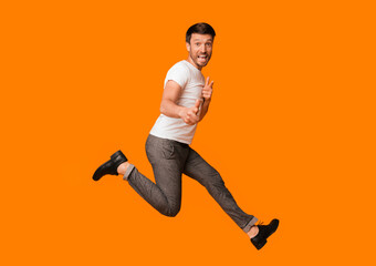 Hey, You. Funny Man Jumping In Rock Star Style Pointing Fingers At Camera Over Yellow Background