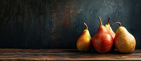 Ripe pears displayed on a wooden table with a dark background, providing a copy space image.