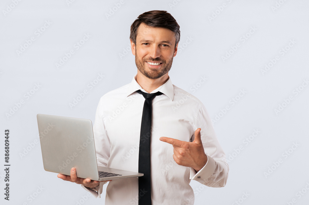 Aufkleber a man in a white shirt and black tie is holding a laptop in his left hand and pointing to the right 